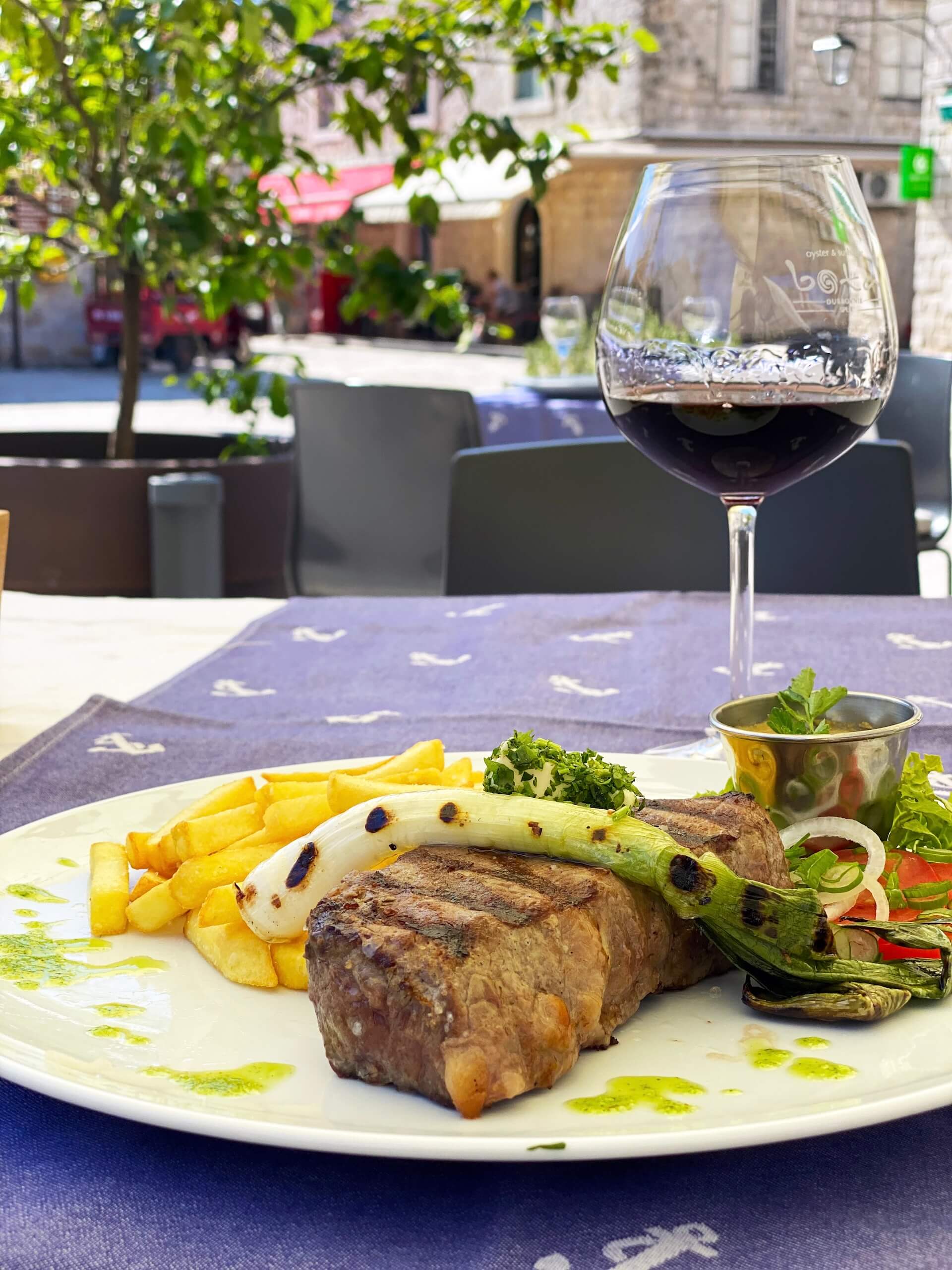 A grilled beef tenderloin with fries and a glass of Pelješac red.