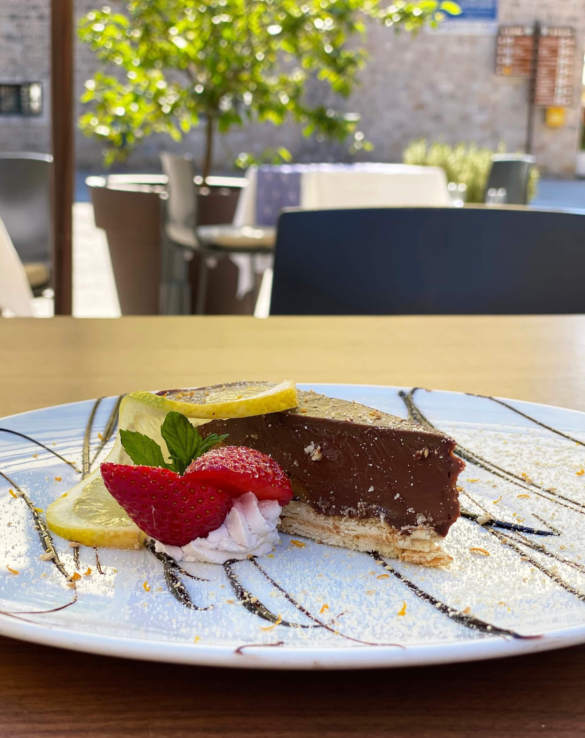 A slice of chocolate Stonska torta with strawberry and mint.
