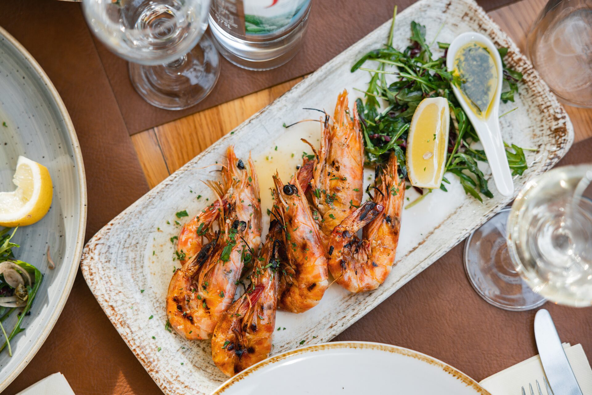 A platter of grilled prawns with rocket and lemon.