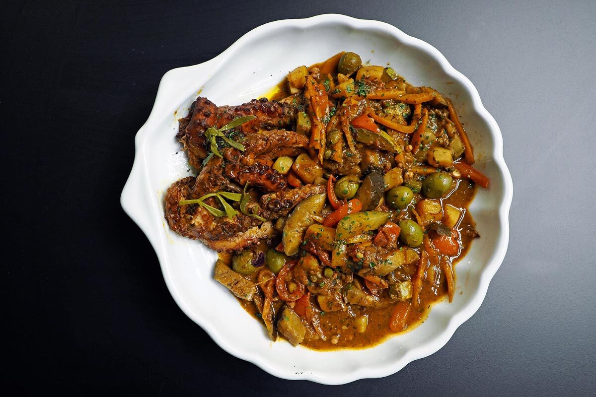 Braised octopus with olives, carrots and vegetables in a rich sauce.